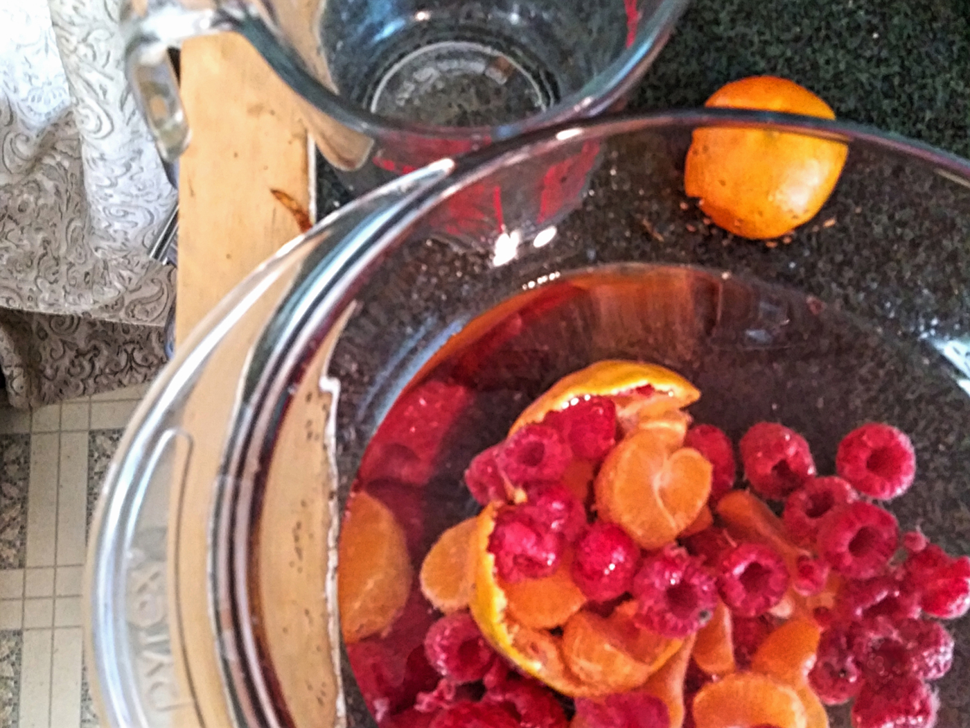 Photo of a bowl of raspberries & mandarain oranges.